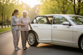 Senior walking towards a sedan vehicle for non-emergency medical transportation